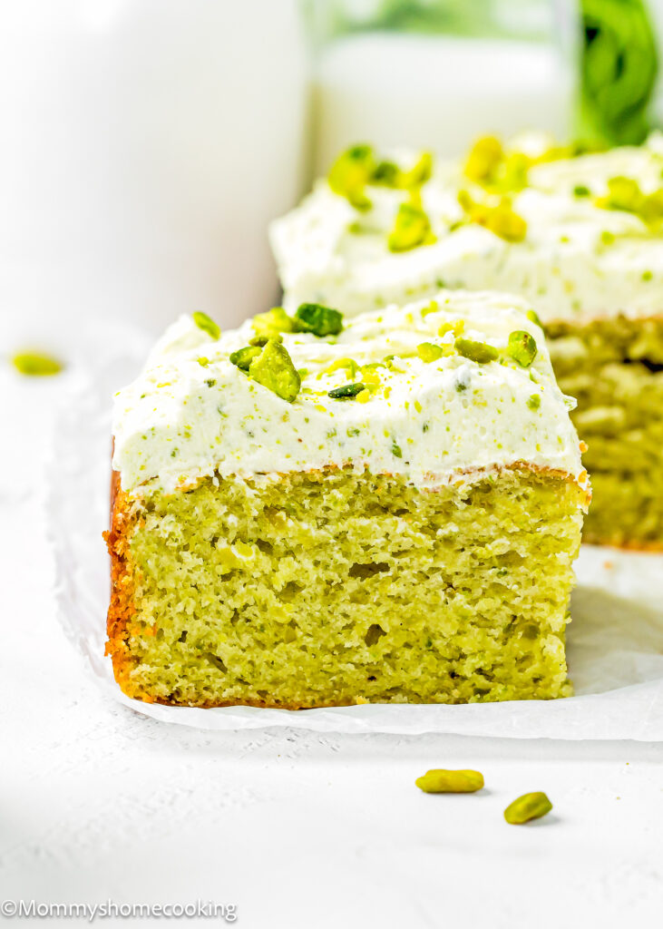 a slice of Easy Pistachio Cake on a piece of parchment paper.